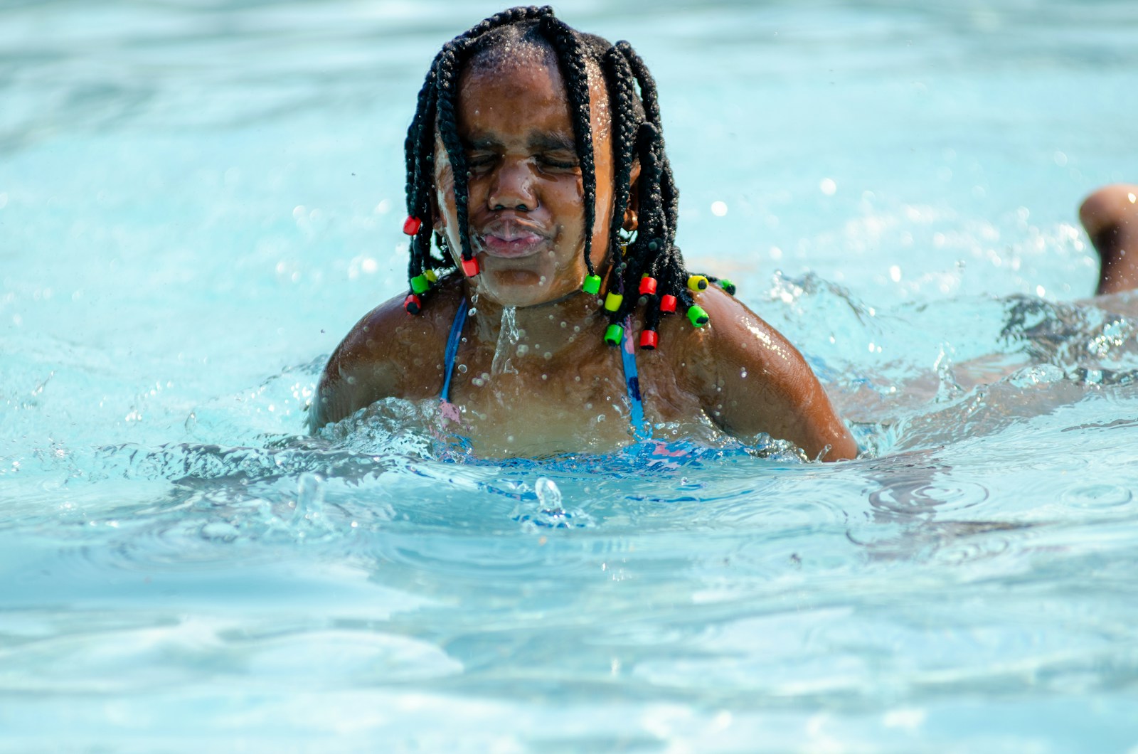 a woman with dreadlocks swimming in a pool